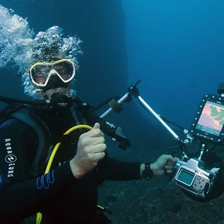 French reporter Alexis Rosenfeld tests a camera connected to a geo-tracking tablet during a diving off the coast of Marseille, on November 1, 2017 before starting his work on the aftermath of hurricane Irma on the coral reef of the French Caribbean island of Saint-Martin.