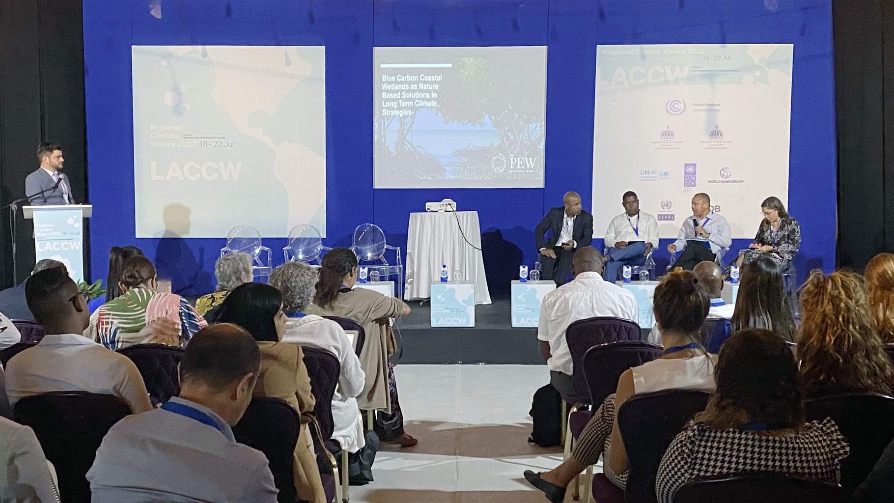 Pew’s Tom Hickey moderates a panel during Latin America and Caribbean Climate Week in Belize focused on blue carbon coastal wetlands, featuring panelists: Colin Young (5Cs), Dr. Kendrick Williams (Belize), Bienvenido Santana (Dominican Republic), and Gabriela Márquez (translator).