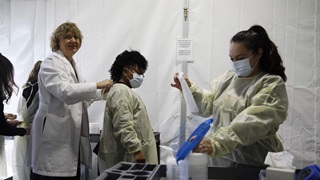 Doctors and health care workers with the UNLV School of Medicine suit up in personal protective equipment before taking patients at a drive thru coronavirus testing site Tuesday, March 24, 2020, in Las Vegas. 