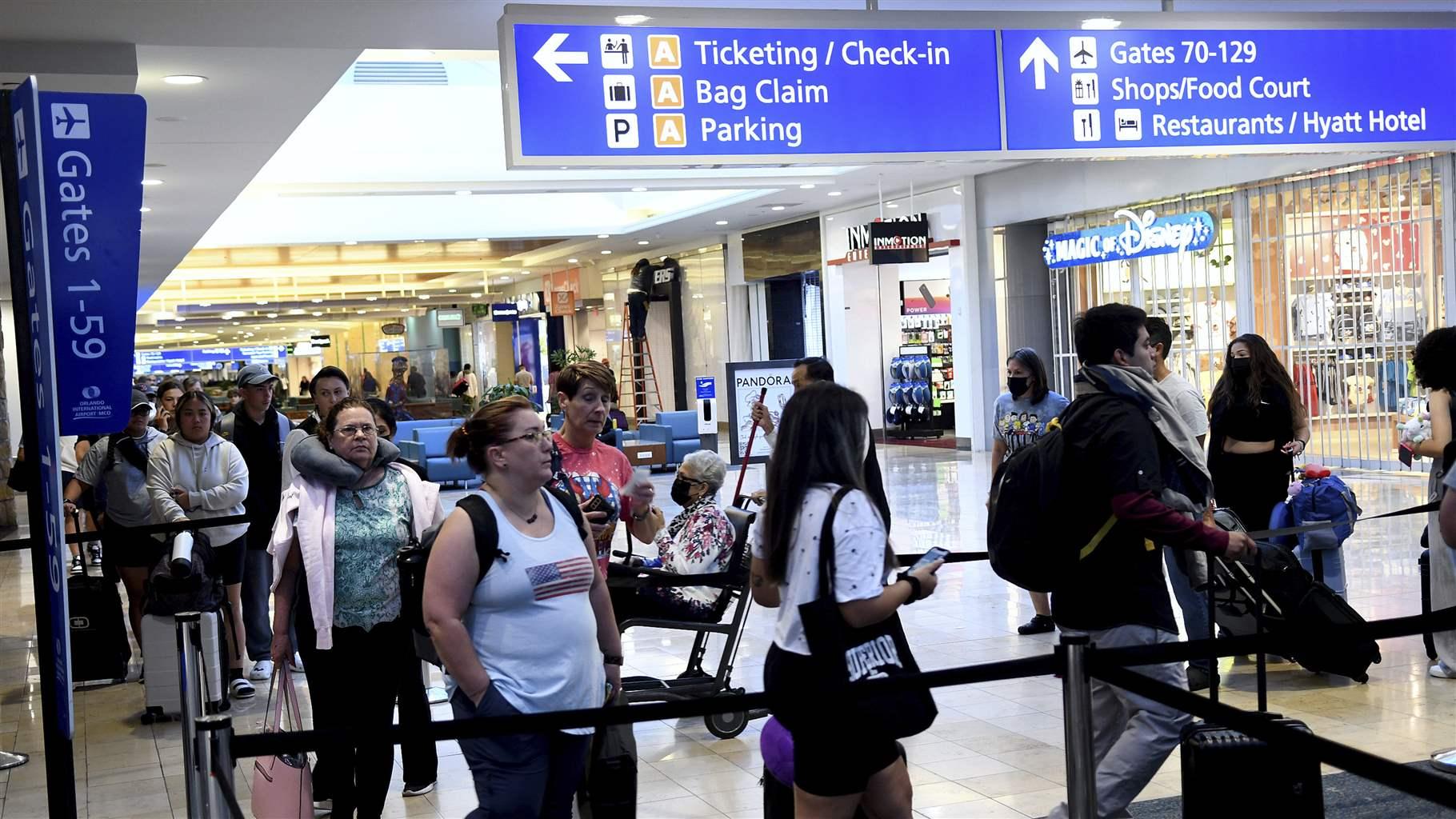 Travelers make their way through a TSA screening line at Orlando International Airport ahead of the July 4 holiday. 