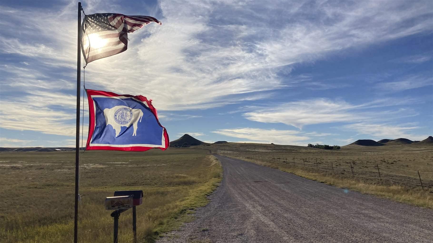  U.S. and Wyoming flags on a rural WO road.