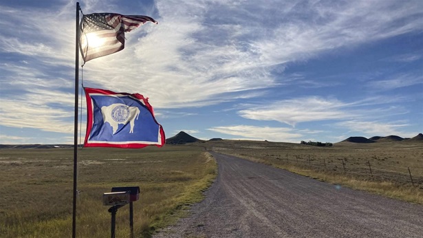 U.S. and Wyoming flags on a rural WO road. U.S. and Wyoming flags on a rural WO road.