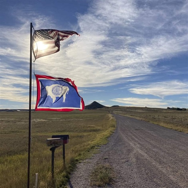  U.S. and Wyoming flags on a rural WO road.