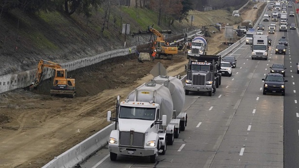 Trucks and other vehicles pass a construction zone on Highway 50 in Sacramento, Calif., Monday, Dec. 6, 2021. 