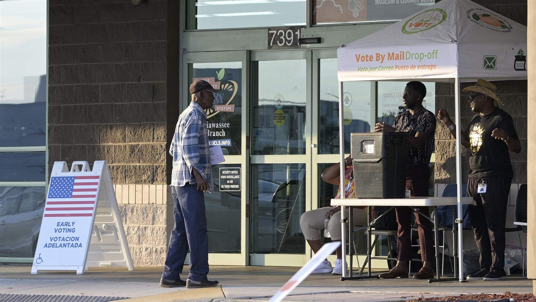 Poll workers man a drop-off ballot box outside an early voting location at a branch of the Orange County Public Library, Wednesday, Oct. 26, 2022, in Orlando, Fla. (Phelan M. Ebenhack via AP) Poll workers man a drop-off ballot box outside an early voting location at a branch of the Orange County Public Library, Wednesday, Oct. 26, 2022, in Orlando, Fla. (Phelan M. Ebenhack via AP)