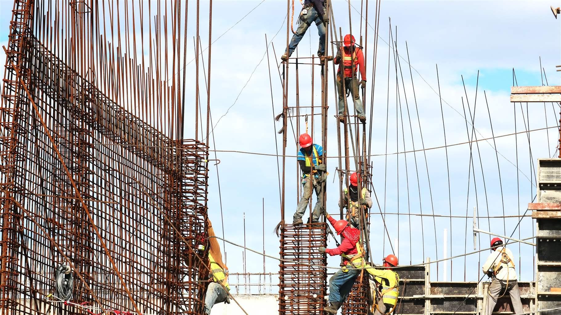 Construction workers climbing infrastructure wires