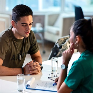 Young army soldier talking with doctor during his therapy