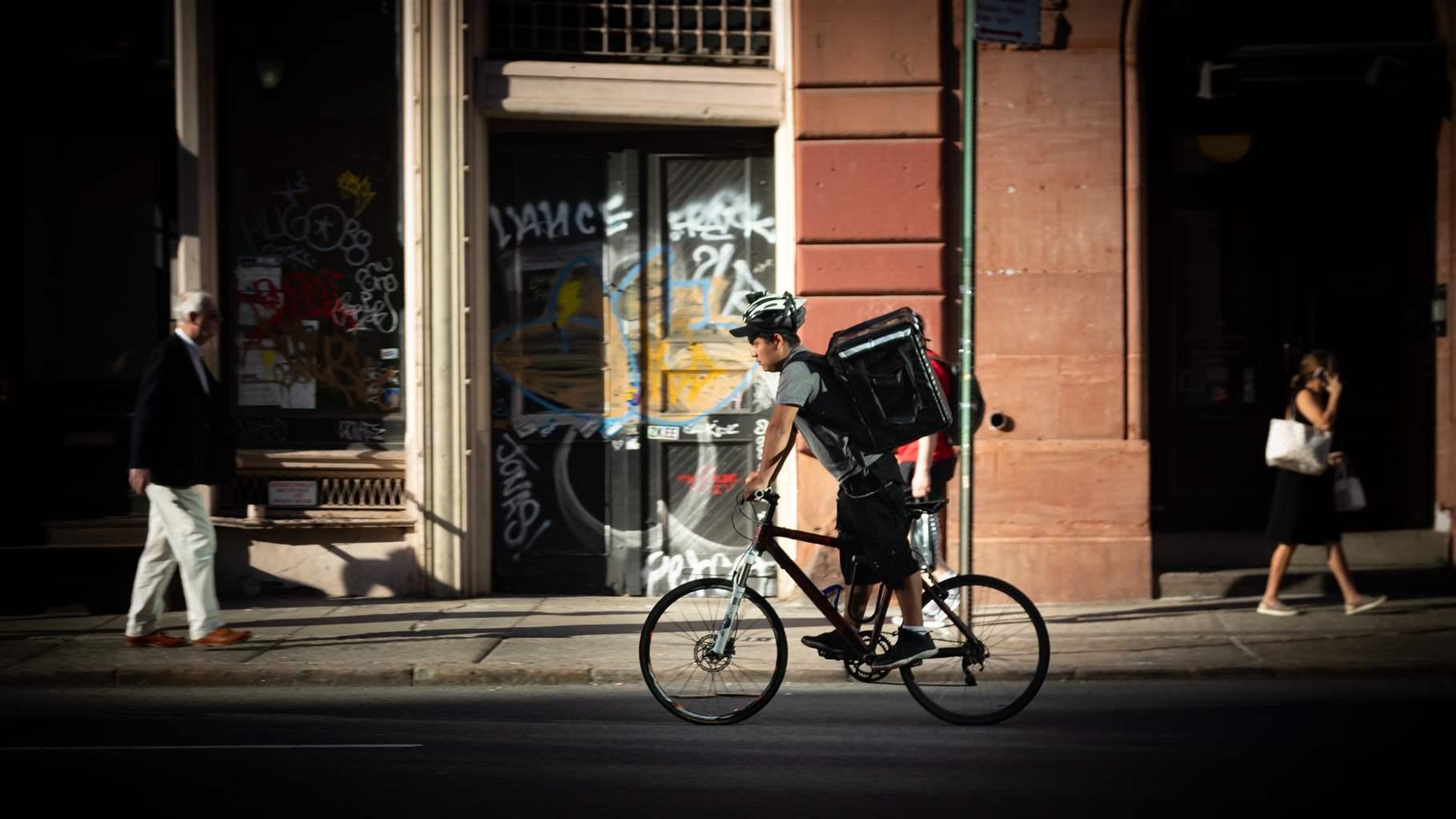 A food delivery gig worker riding a bike on the streets