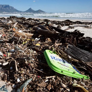Litter, mostly plastic, lies on a beach close to the city centre, tangled up with kelp (type of sea plant), with Table Mountain in the background on June 3, 2018, in Cape Town