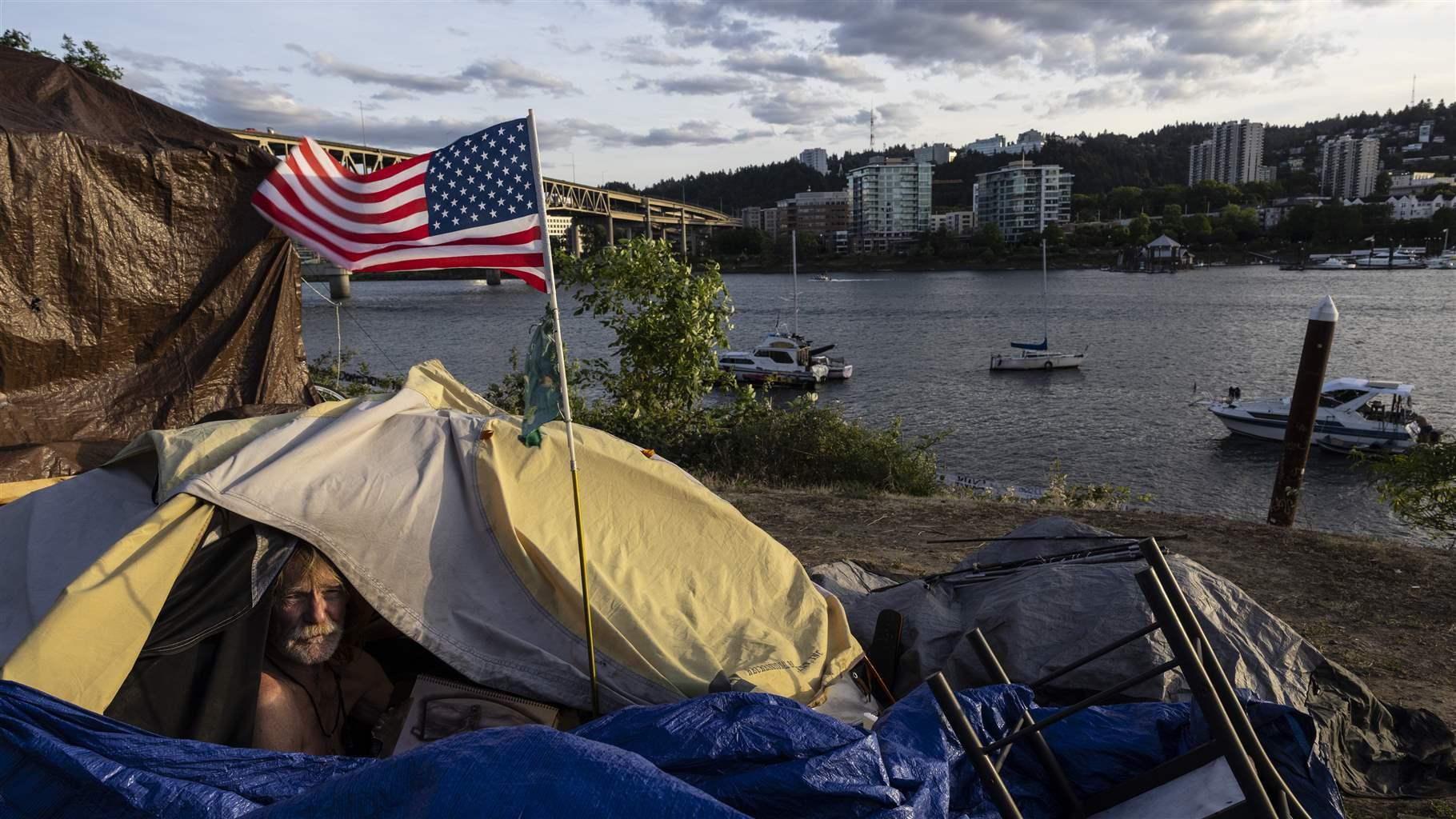 Oregon Legislature Homelessness Frank, a homeless man, sits in his tent with a river view in Portland, Ore., on June 5, 2021.