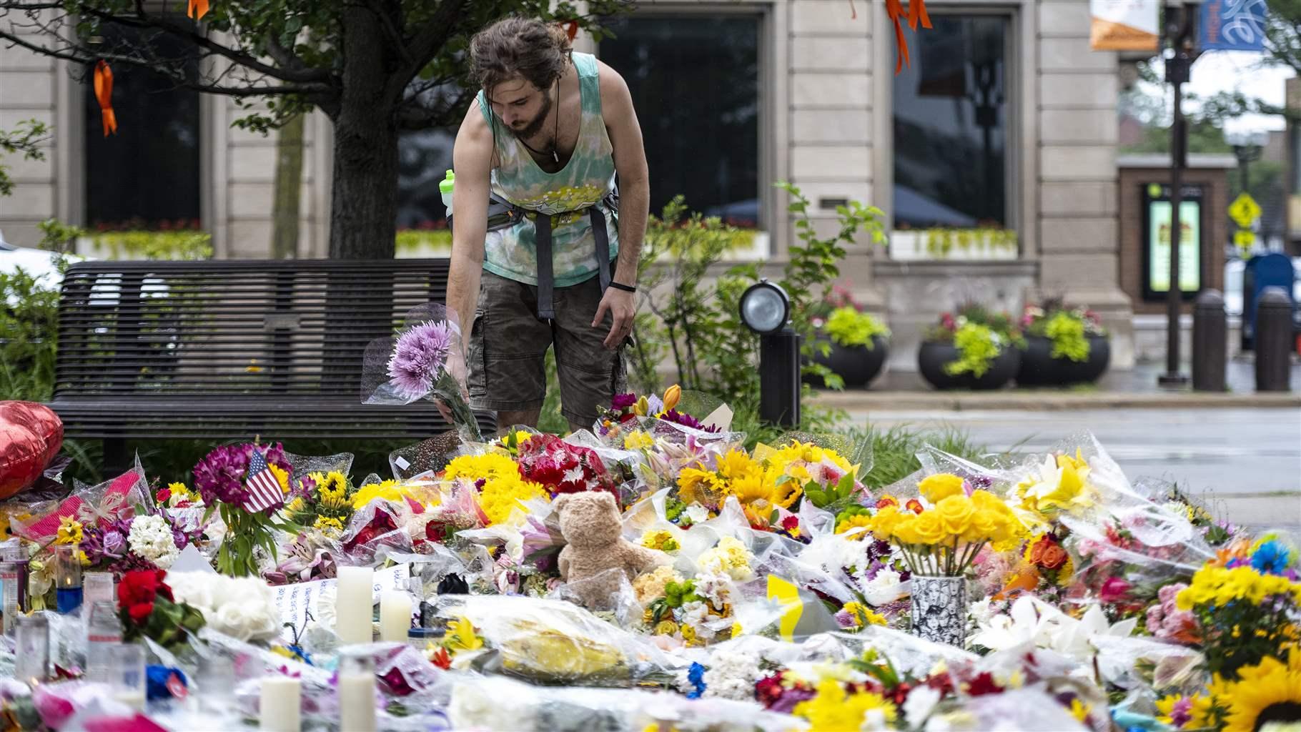 A mourner places flowers at a memorial to the victims of the July 4th mass shooting in Highland Park, IL on Friday July 8, 2022. (Photo by Christopher Dilts / Sipa USA)(Sipa via AP Images)