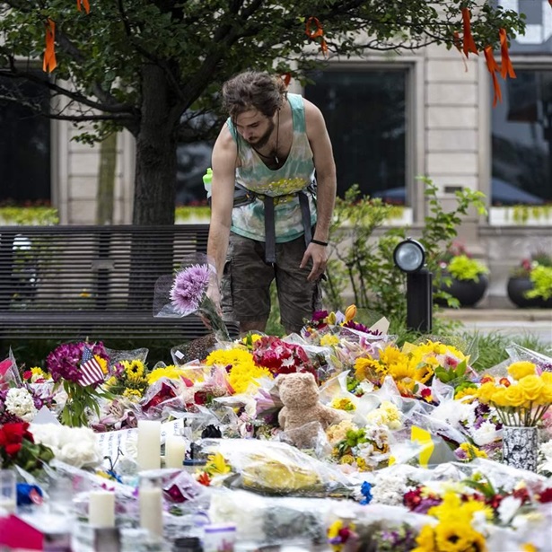 A mourner places flowers at a memorial to the victims of the July 4th mass shooting in Highland Park, IL on Friday July 8, 2022. (Photo by Christopher Dilts / Sipa USA)(Sipa via AP Images)