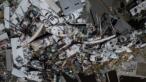 An aerial picture taken on September 29, 2022 shows piled up boats in the aftermath of Hurricane Ian in Fort Myers, Florida. - Hurricane Ian left much of coastal southwest Florida in darkness early on Thursday, bringing "catastrophic" flooding that left officials readying a huge emergency response to a storm of rare intensity. 