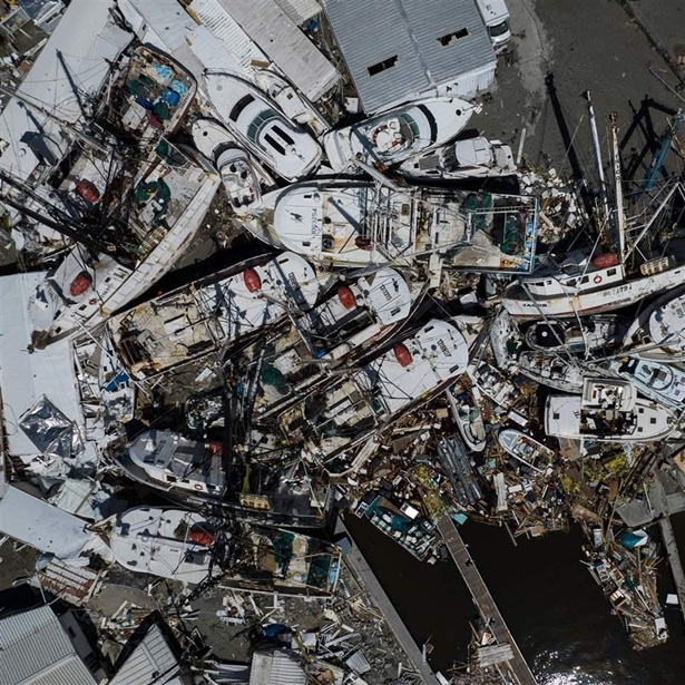 An aerial picture taken on September 29, 2022 shows piled up boats in the aftermath of Hurricane Ian in Fort Myers, Florida. - Hurricane Ian left much of coastal southwest Florida in darkness early on Thursday, bringing "catastrophic" flooding that left officials readying a huge emergency response to a storm of rare intensity. 