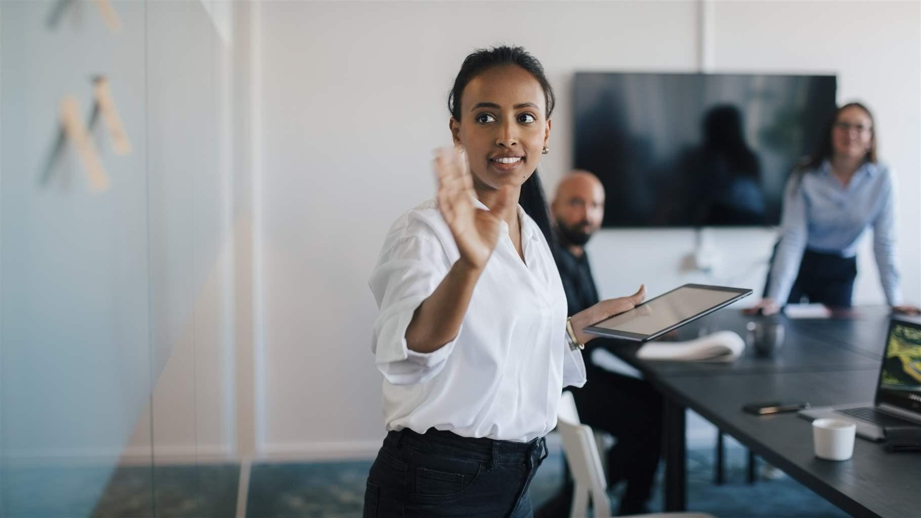 Businesswoman brainstorming over adhesive notes in meeting at board room