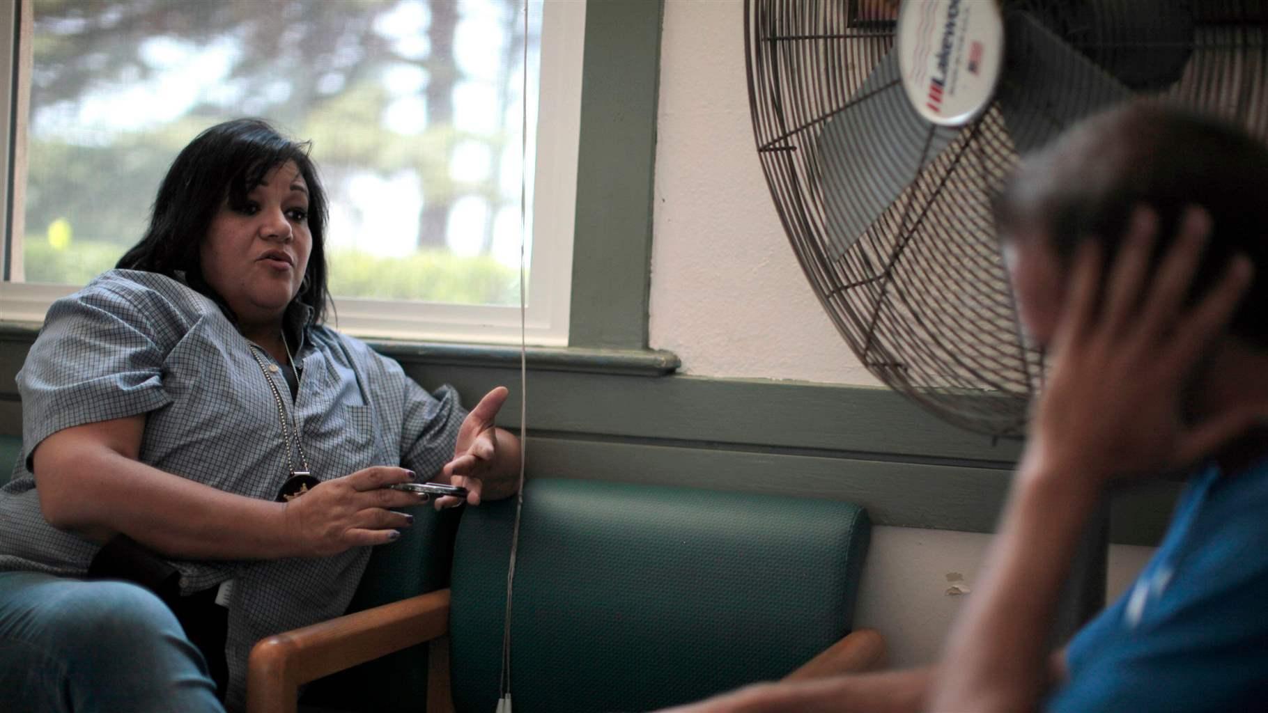 Orange County Deputy Probation Officer Christine Torres talks to a probationer who has broken the terms of his probation in Santa Ana, California 