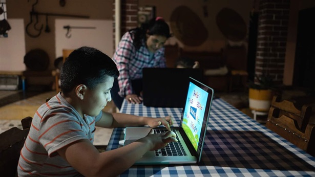 Latin American kids studying at home using laptop computers with the supervision of his mother - education concepts