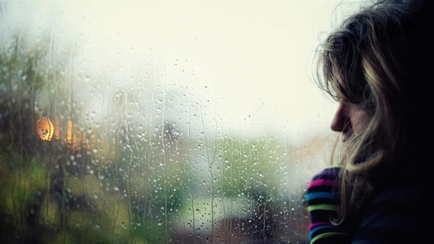 Woman at window during rain