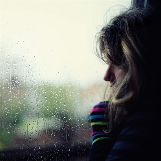 Woman at window during rain