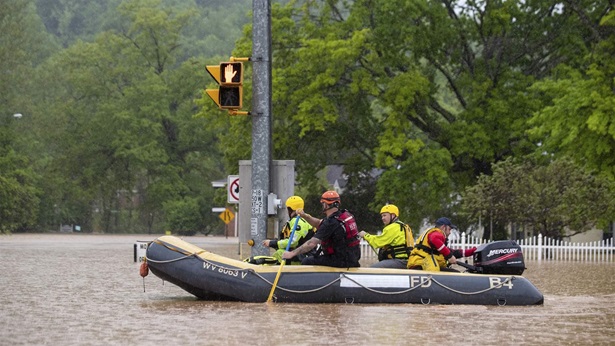 First responders launch a boat along a flooded Hal Greer Boulevard as they go to check on residents in Enslow Park on Friday, May 6, 2022, in Huntington.