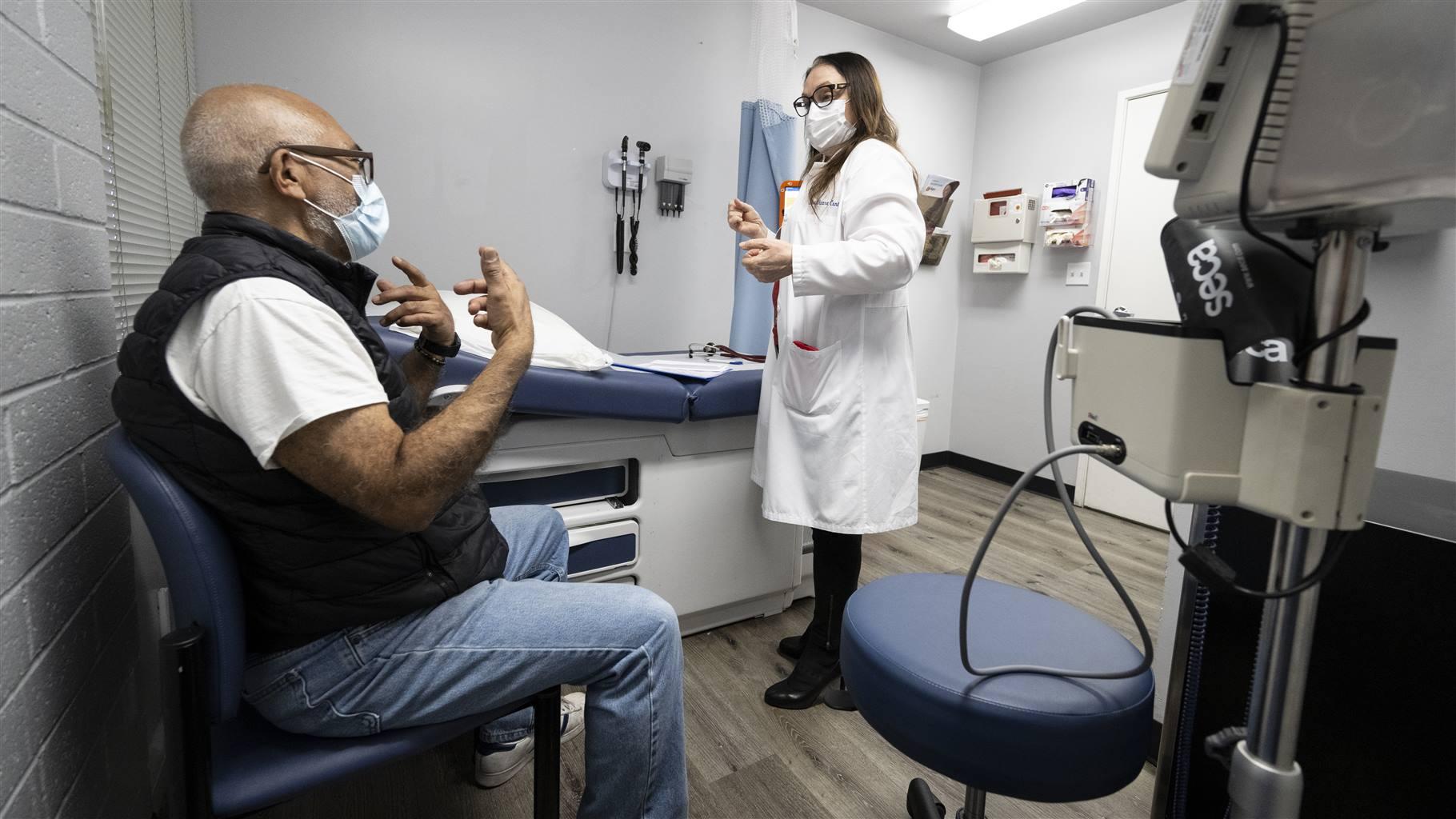 A man talks with Dr. Stela Kostova at Families Together of Orange County in Tustin, CA on Tuesday, February 21, 2023