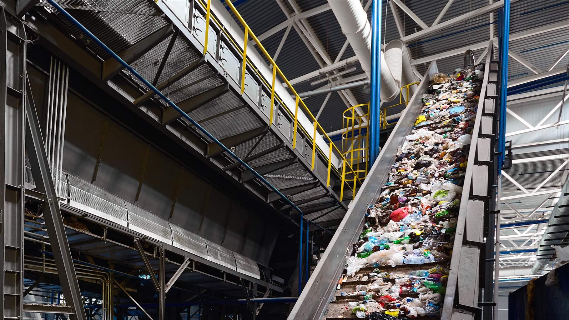 A conveyor belt transports waste—much of it bags, bottles and other items made from plastic—at a recycling plant. 