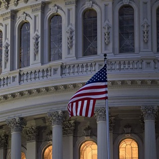 The American flag flies outside the U.S. Capitol before sunrise in Washington, D.C., U.S. Photographer: Andrew Harrer/Bloomberg